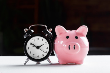 Alarm clock and piggy bank concept for saving time