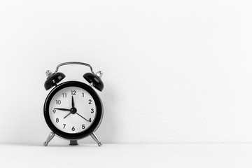 Black vintage alarm clock on a white background close up
