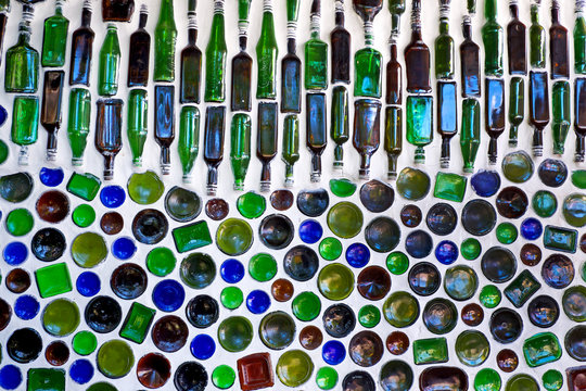 one hundred glass bottles used as building material the Glass Bottles are built into a white wall