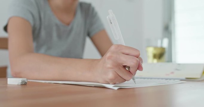 Woman take note on paper at home
