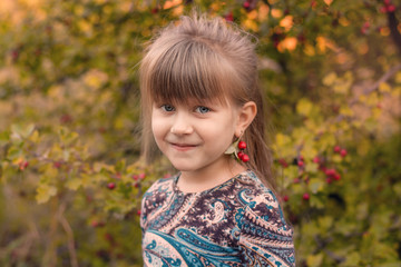  Beautiful girl with long hair at sunset in the forest. Portrait of a girl. Baby with berries in hand at sunset