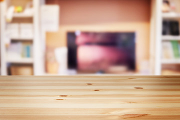 a wooden table with background of blurry interior living room at modern house