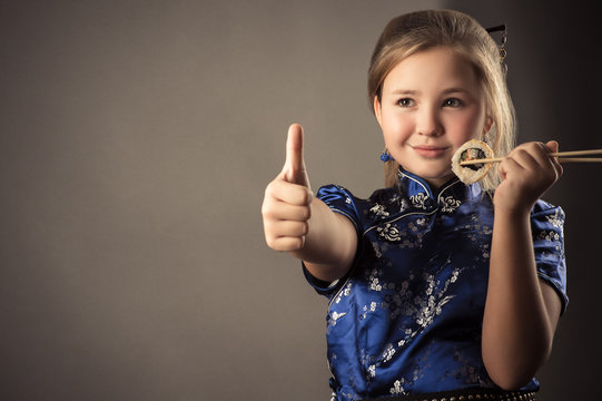 Smiling Child Girl With Roll In Hand Shows Gesture Thumb Up