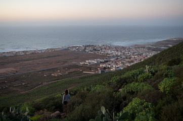 Woman enjoying the sunset with view towards Sidi Ifni.