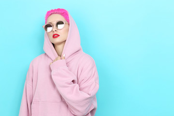 Fashion portrait of young hipster woman in pink hoody. Short pink hair