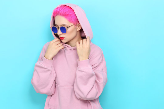Fashion portrait of young hipster woman in pink hoody. Short pink hair