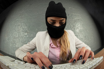 masked business woman steals data from a computer