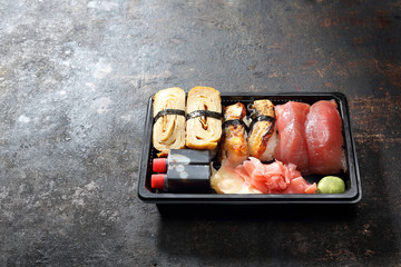 Nigiri sushi na ciemnym tle. Tacka z kawałkami sushi , imbirem , wasabi i sosem sojowym na ciemnym tle. - obrazy, fototapety, plakaty
