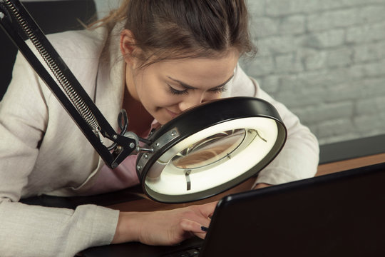 business woman working with a magnifying glass, computer blindness