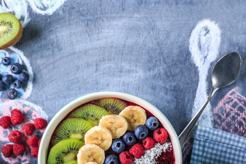 Healthy breakfast with delicious acai smoothie in bowl on chalk board