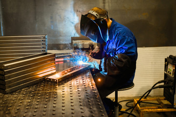 Working welder welds parts factory - obrazy, fototapety, plakaty