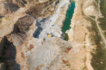 Extraction of minerals by the open method. Mining, extraction of rocks by an excavator. Aerial view