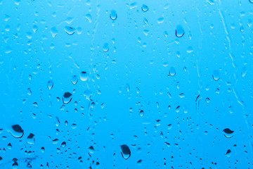 Natural water drop background on glass. Blurred city