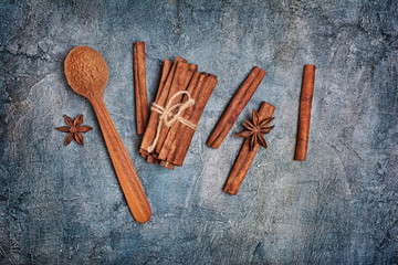 Top view of ingredients for spicy beverage or confectionery - cinnamon sticks and powder with anise stars