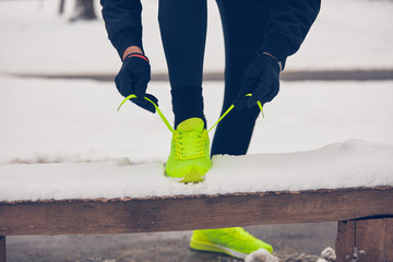 Detail of man's legs jogging in the park at snowy time.
