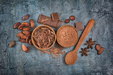 Top view of chocolate chips, bar and cocoa powder with spices