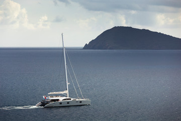 Sailing ship yacht with the island on a background