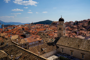 Urban landscape of an old medieval town with red rooftops and churches on a sunny summer day.  Cityscape of the Old City of Dubrovnik in Croatia.