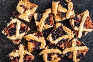 Homemade shortbread cookies with jam on black background.