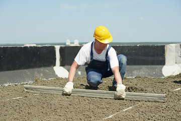 Roof construction. worker roofer leveling with float lute