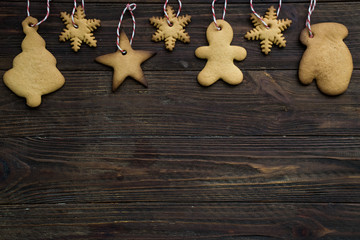Hand made New Year's toys of cookies on a brown wooden background. Top view. Copy space