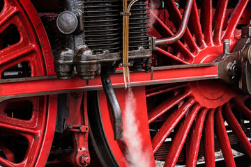 Detail of a steam locomotive with white Steam, white Steam, Detail of Big red Wheels, rod Drive