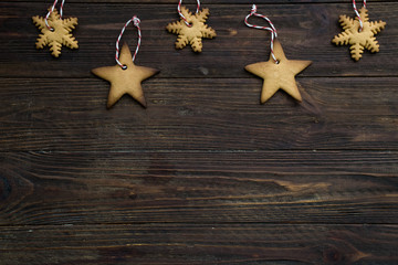 Hand made New Year's toys of cookies on a brown wooden background. Top view. Copy space