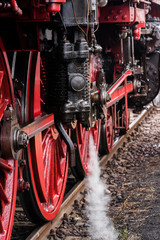 Detail of a steam locomotive with white Steam, white Steam, Detail of Big red Wheels, rod Drive of a germany steam loco