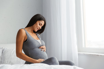 Beautiful young pregnant woman at home