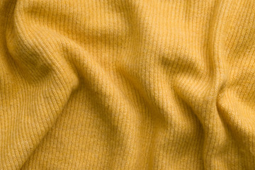 Texture of a yellow knitted sweater. Knitted background
