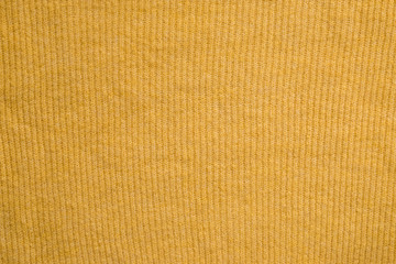 Texture of a yellow knitted sweater. Knitted background