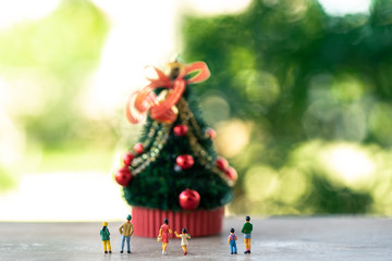 Family Miniature people standing on Christmas tree Celebrate Christmas on December 25 every year. using as background xmas concept with copy spaces for you