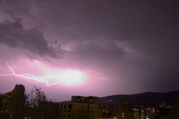 Beautiful lightning at night over nighttime cityscape