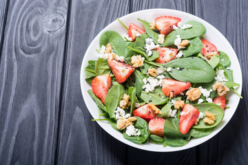 Strawberry salad with spinach , cheese and walnut . Healthy food