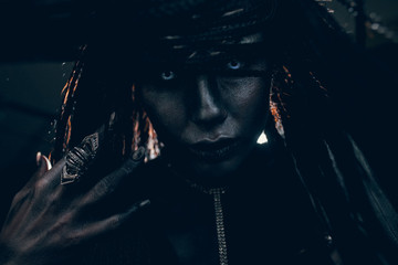 Portrait of woman in image of extraterrestrial alien with finger ring on her hand and demonic eyes.