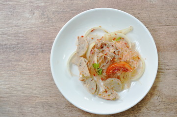 spicy glass noodles with slice Vietnamese sausage and onion Thai salad on plate