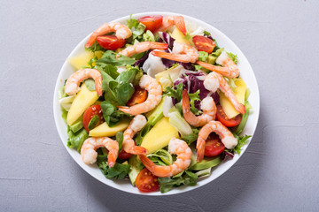 Mix of salad with shrimps , avocado and cherry tomatoes . Healthy food background