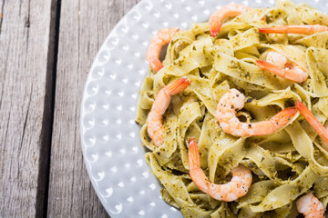 Pasta tagliatelle with sauce pesto and shrimps . Italian food background