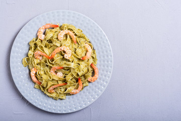 Pasta tagliatelle with sauce pesto and shrimps . Italian food background