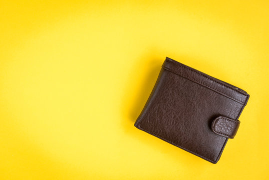 Brown men's wallet on yellow background.