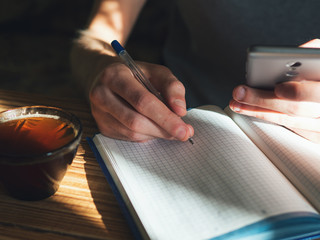 A man with a Cup of coffee and a notebook at the table