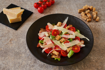 Caesar salad on a black plate, ingredients