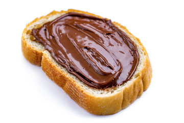 Isolated piece of loaf with spread chocolate paste on a white background. Sweet, nut butter with fresh bread for breakfast.
