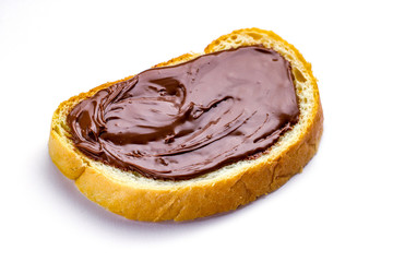 Isolated piece of loaf with spread chocolate paste on a white background. Sweet, nut butter with fresh bread for breakfast.