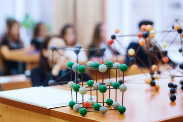School children in a science class with a molecular model. Background image with soft focus....
