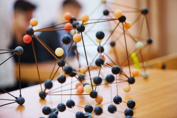 School children in a science class with a molecular model. Background image with soft focus. Education concept
