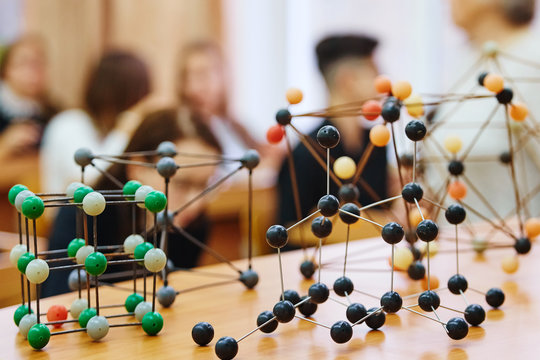 School children in a science class with a molecular model. Background image with soft focus. Education concept