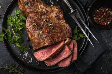 sliced beef steak on black plate - obrazy, fototapety, plakaty