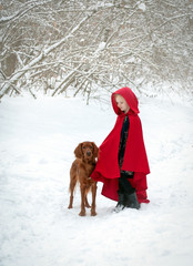 Girl in a red coat with a dog in the snow