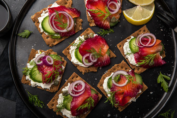 healthy sandwiches with wholegrain rye crisp bread, cream cheese, beet cured salmon and cucumber